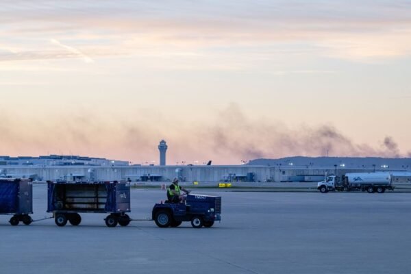 The ATC tower is seen while smoke rises from the crash site of UPS Flight 2796 near Louisville Muhammad Ali International Airport on Wednesday. Jon Cherry/AP