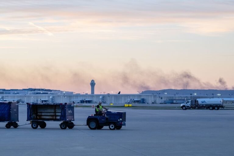 The ATC tower is seen while smoke rises from the crash site of UPS Flight 2796 near Louisville Muhammad Ali International Airport on Wednesday. Jon Cherry/AP